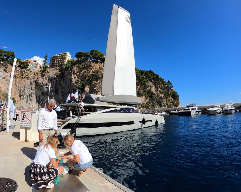 Préparartion d'un prélèvement, en arrière-plan le catamaran Modx 70 et sa voile gonflable.