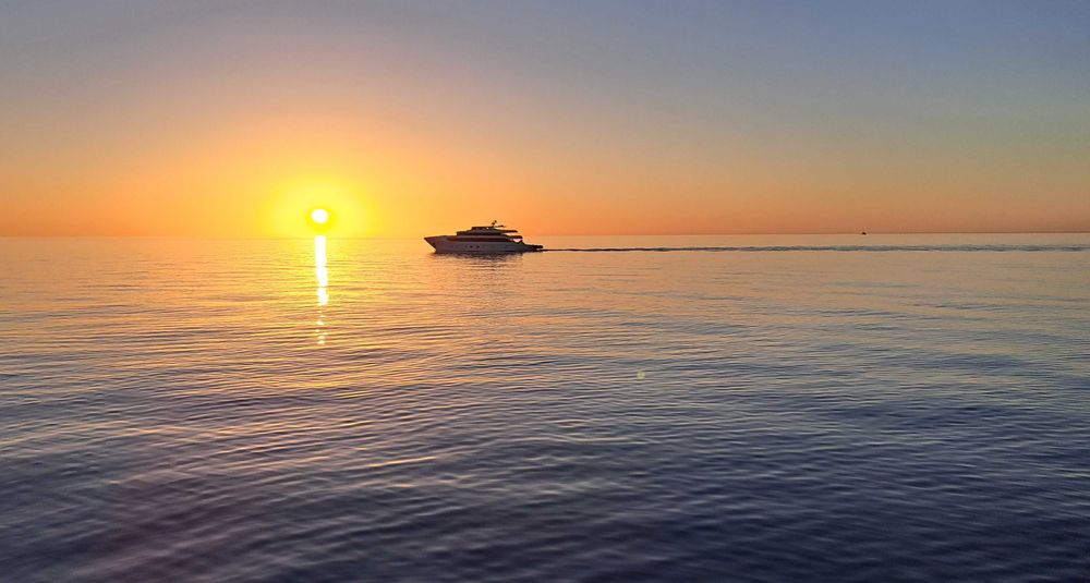 Un navire naviguant au coucher du soleil