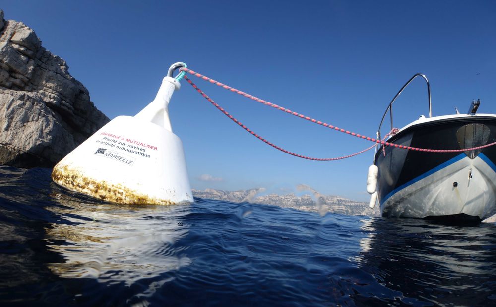 Un bateau amarré à une bouée blanche